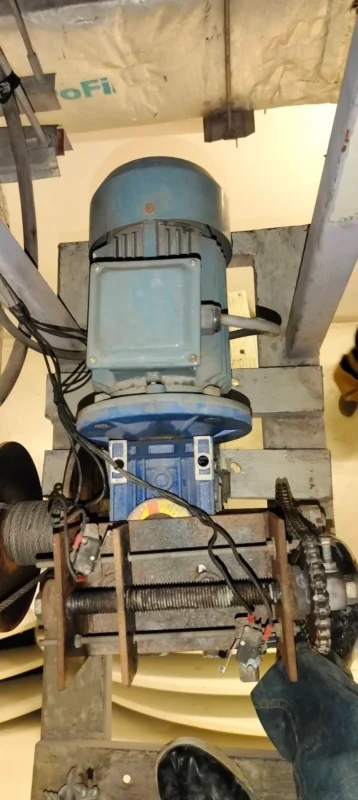 ทีมช่าง zeuscorp กำลังปฏิบัติงานตรวจสอบและปรับปรุงระบบรอกสลิงไฟฟ้า (Motor Hoist) บนที่สูง ณ หอประชุมมหาวิทยาลัยกรุงเทพ